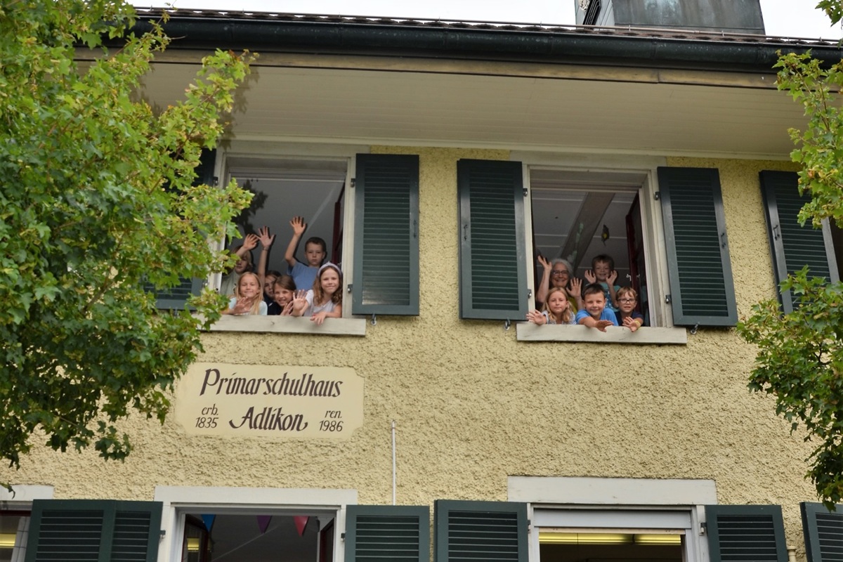 Ein letzter Abschiedsgruss von den Erst- und Zweitklässlern aus Adlikon. Im Fenster oben rechts Christine Keller